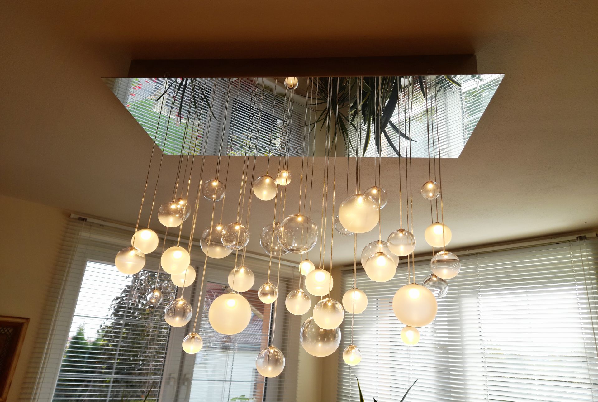 Warm white coloured chandelier in rustical kitchen with dinning room