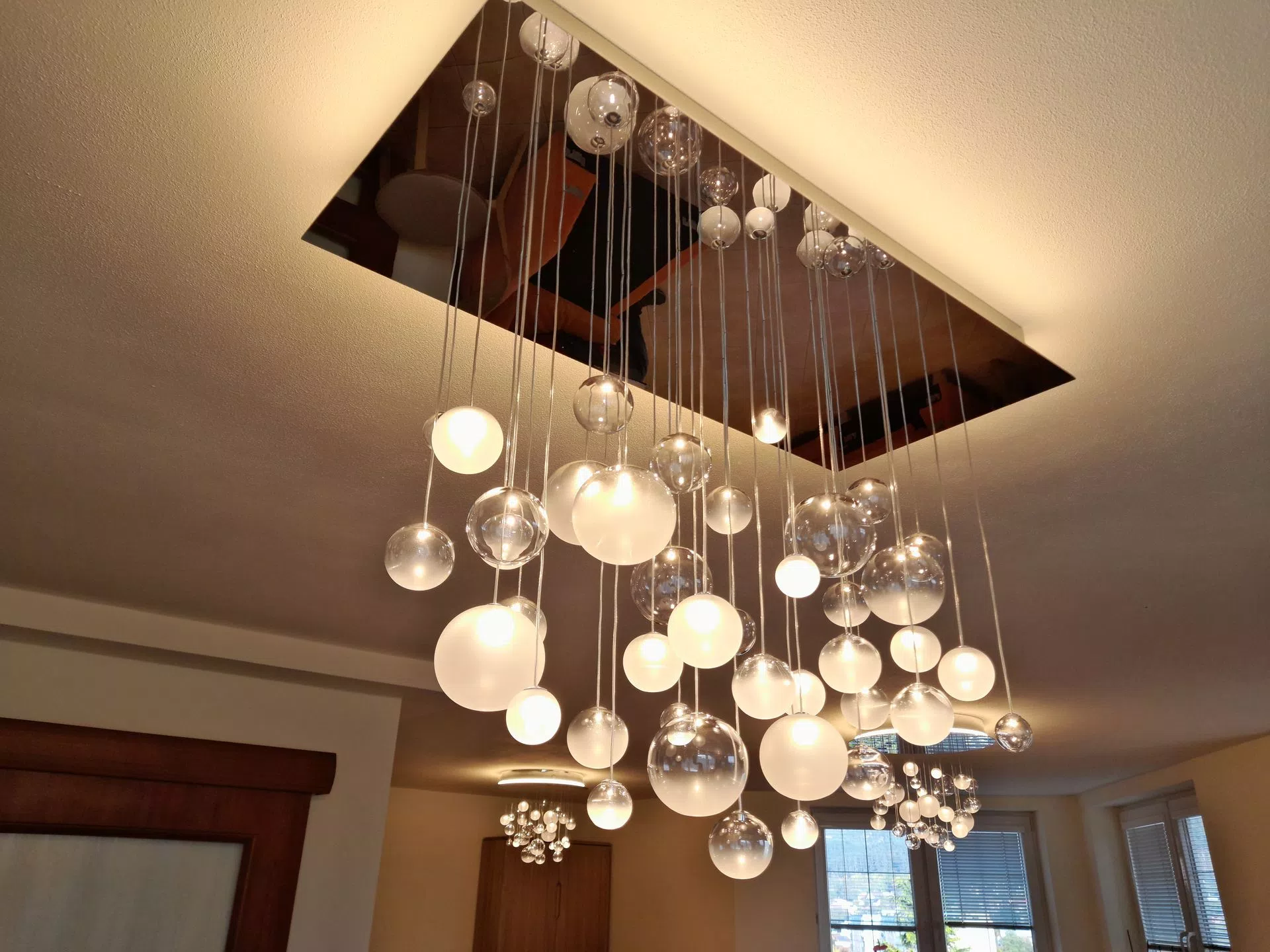 Two modern chandeliers in rustical interior fit nicely