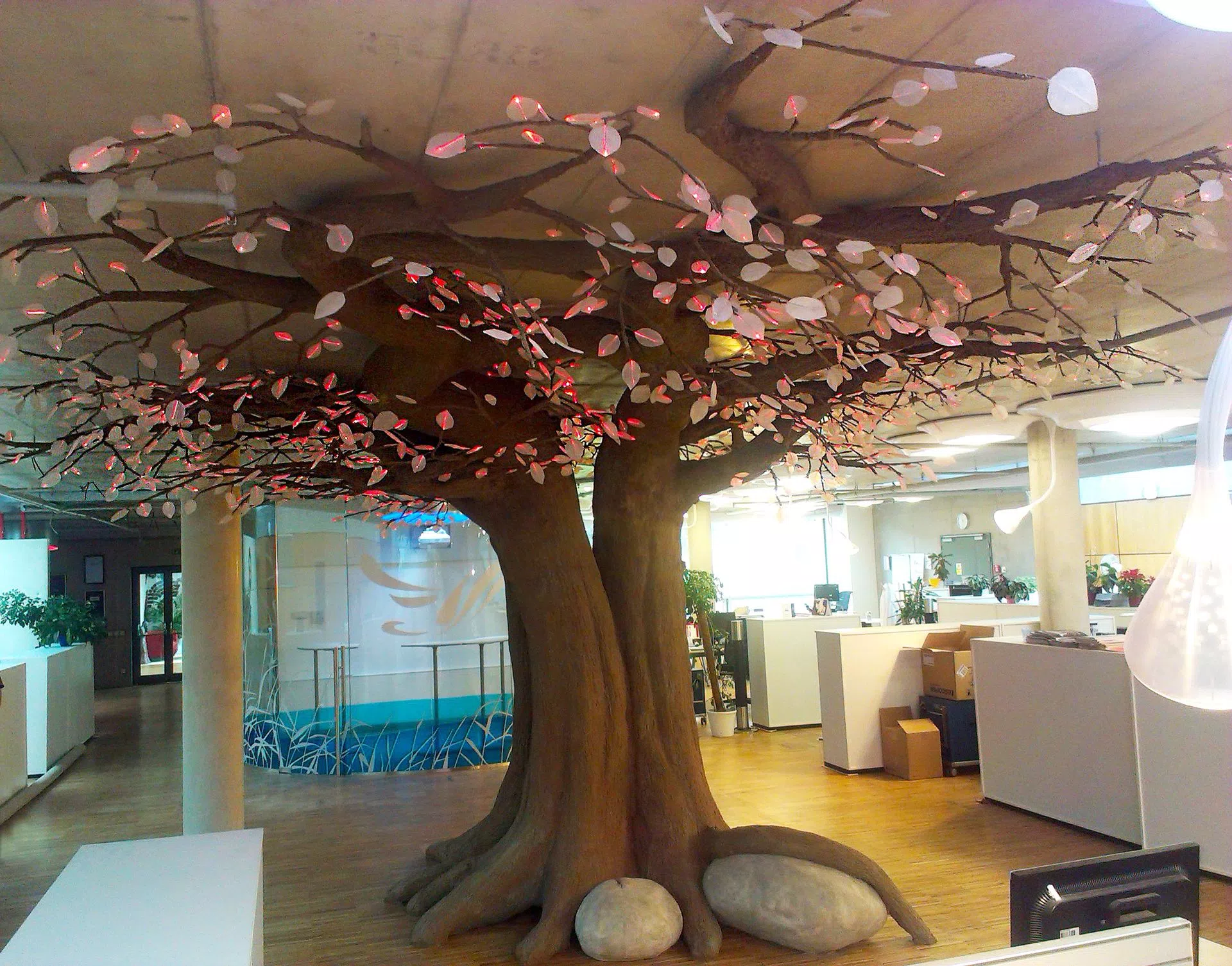 Red coloured fibre optic tree sculpture in office, during daytime