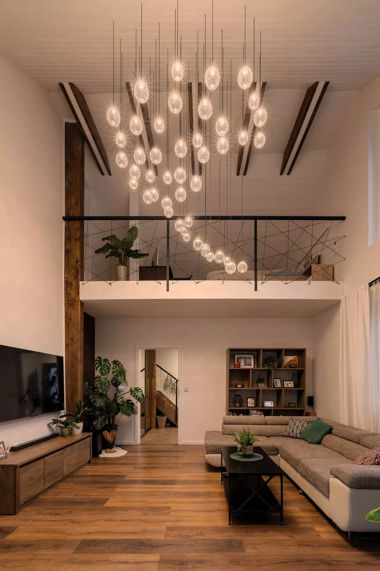 ELUDA soda glass chandelier in tall livingroom with programmed effects and scenes to power up the space in interesting way