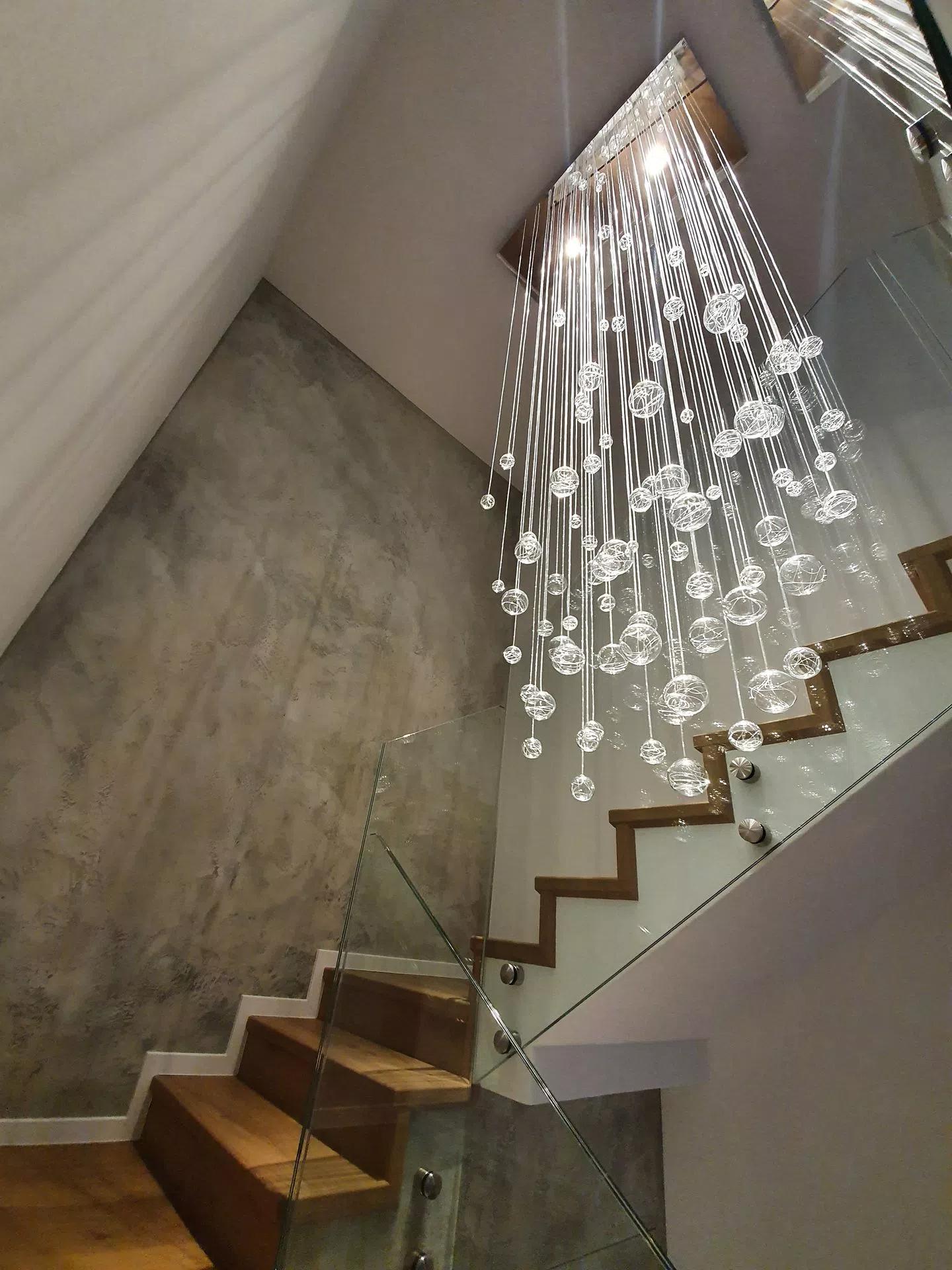 Sideview fibre optic chandelier on staircase with switched on LED downlights