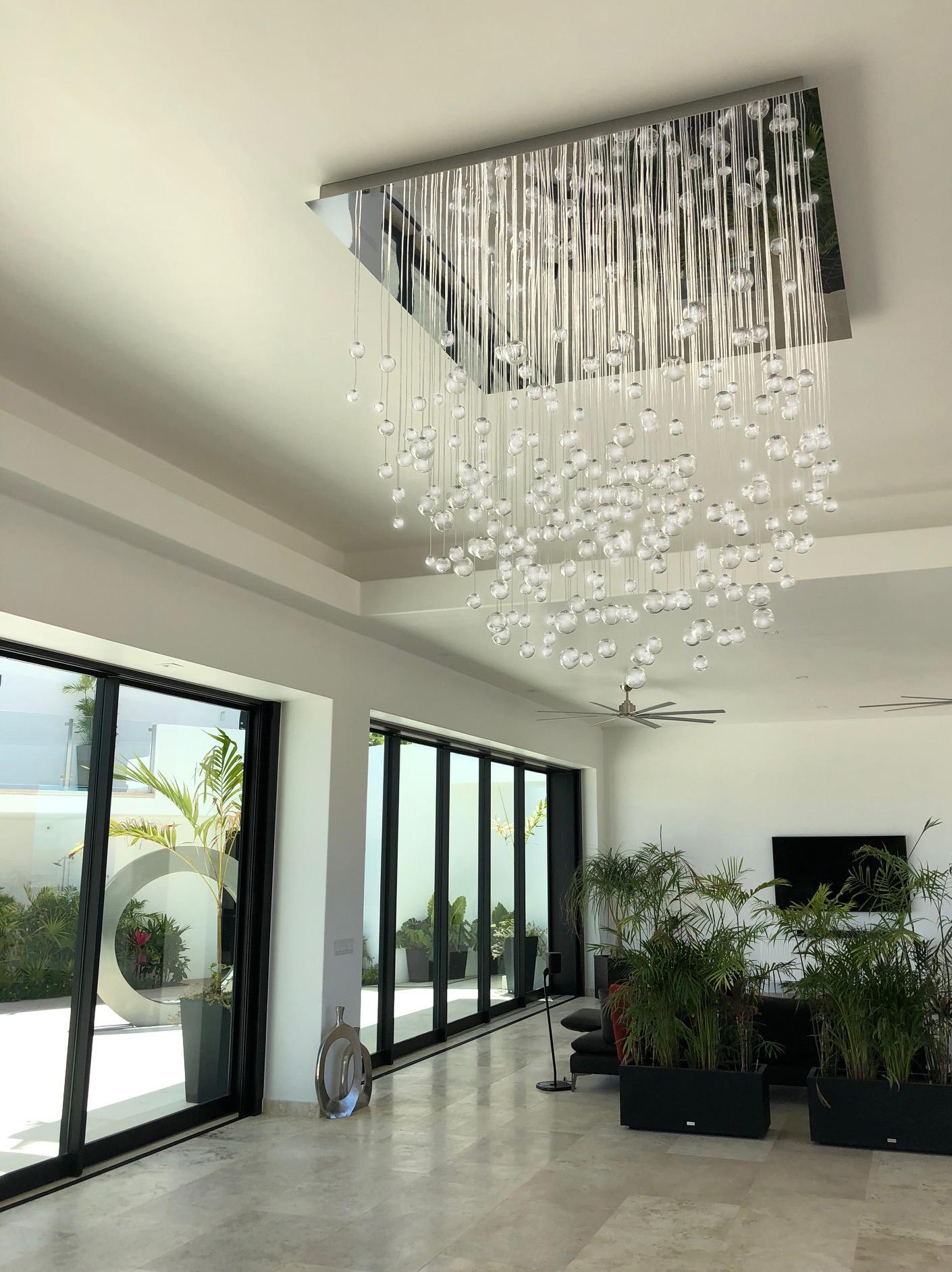 Seaside villa massive fibre optic chandelier AQUILA in antrance hall from sea view in daytime