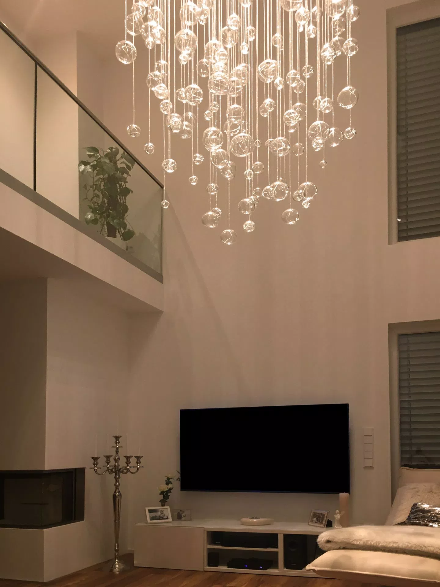 tall chandelier aquila in livingroom above TV